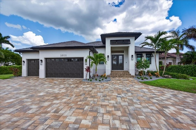 3800 Carupano Ct, Punta Gorda, FL 33950 - prairie-style house featuring an attached garage, decorative driveway, and stucco siding