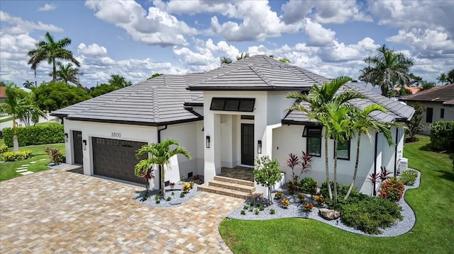 3800 Carupano Ct, Punta Gorda, FL 33950 - view of front of house featuring an attached garage, stucco siding, decorative driveway, a front yard, and a tiled roof