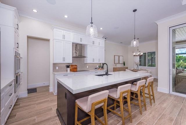 3800 Carupano Ct, Punta Gorda, FL 33950 - kitchen featuring wall chimney exhaust hood, light countertops, light wood-style floors, white cabinetry, and tasteful backsplash