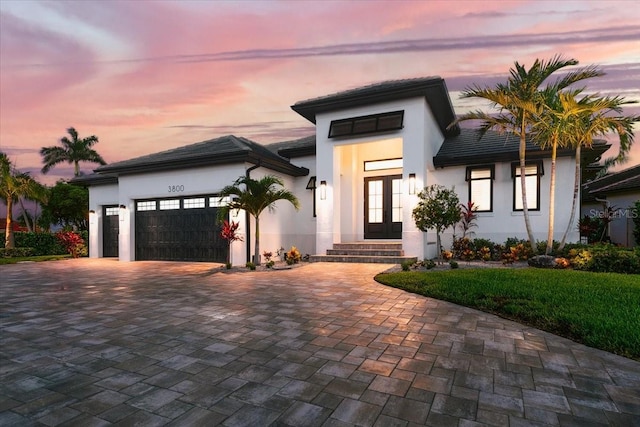 3800 Carupano Ct, Punta Gorda, FL 33950 - view of front of house with french doors, a garage, decorative driveway, and stucco siding