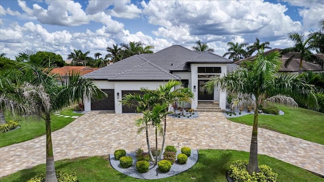 3800 Carupano Ct, Punta Gorda, FL 33950 - view of front of home with stucco siding, a garage, a front yard, driveway, and a tiled roof