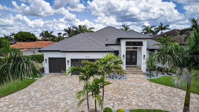 3800 Carupano Ct, Punta Gorda, FL 33950 - modern home featuring french doors, a garage, stucco siding, and driveway