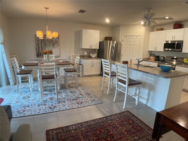 25228 E Lenox Cir, Punta Gorda, FL 33950 - kitchen featuring appliances with stainless steel finishes, a chandelier, dark countertops, ceiling fan, and white cabinets