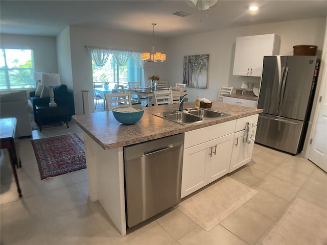 25228 E Lenox Cir, Punta Gorda, FL 33950 - kitchen featuring stainless steel appliances, light tile patterned floors, white cabinets, a kitchen island with sink, and plenty of natural light