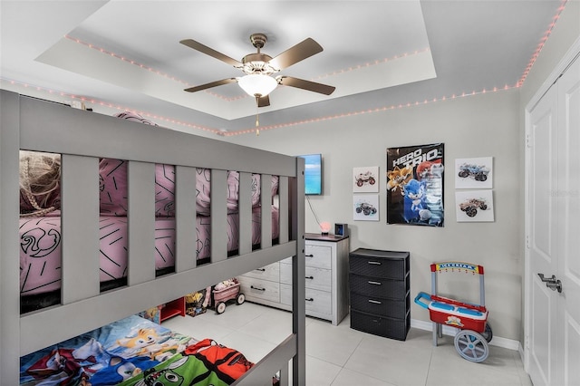 1731 NW 24th Pl, Cape Coral, FL 33993 - bedroom featuring a tray ceiling, tile patterned flooring, and a ceiling fan