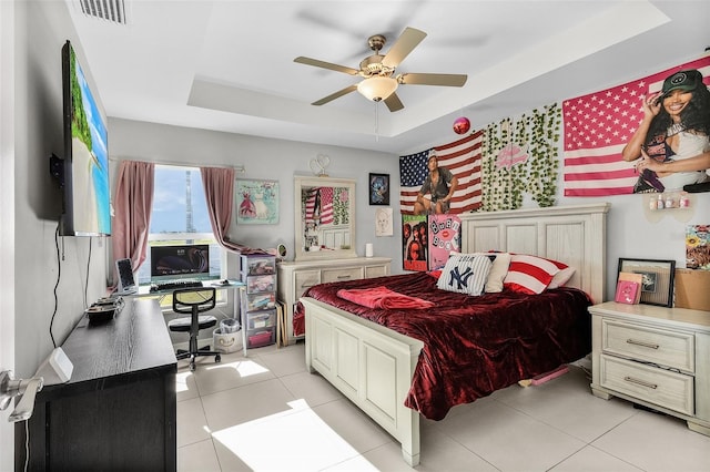 1731 NW 24th Pl, Cape Coral, FL 33993 - bedroom featuring a tray ceiling, light tile patterned flooring, ceiling fan, and an office area