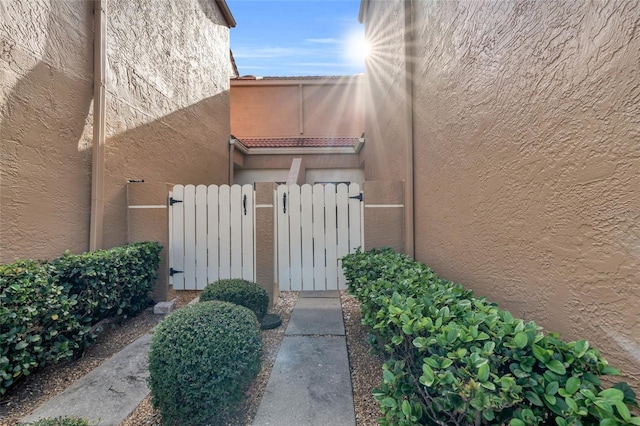 7150 Golden Eagle Ct Unit 213, Fort Myers, FL 33912 - view of exterior entry with stucco siding and a gate