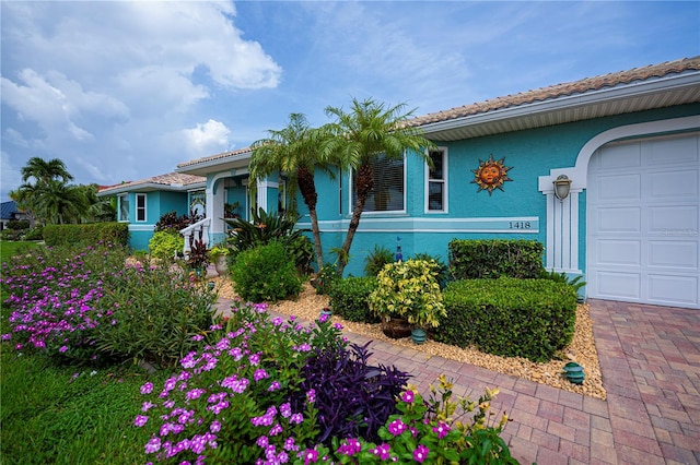 1418 Grebe Dr, Punta Gorda, FL 33950 - view of front of house with stucco siding, a garage, and a tile roof