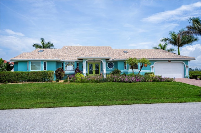 1418 Grebe Dr, Punta Gorda, FL 33950 - ranch-style house with an attached garage, a front lawn, driveway, stucco siding, and french doors