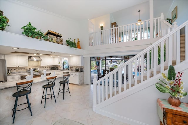 1418 Grebe Dr, Punta Gorda, FL 33950 - kitchen with stainless steel appliances, wall chimney range hood, decorative backsplash, white cabinets, and a high ceiling