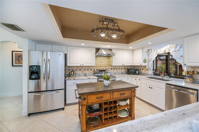 1418 Grebe Dr, Punta Gorda, FL 33950 - kitchen featuring appliances with stainless steel finishes, a tray ceiling, wall chimney range hood, and decorative backsplash