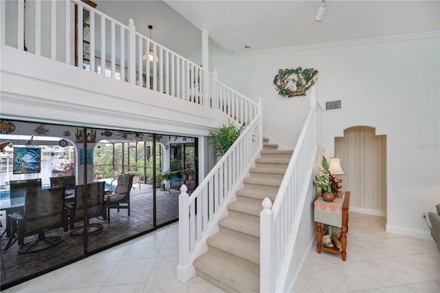 1418 Grebe Dr, Punta Gorda, FL 33950 - stairs featuring tile patterned flooring, a towering ceiling, arched walkways, and french doors