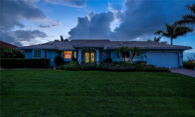 1418 Grebe Dr, Punta Gorda, FL 33950 - ranch-style house featuring a tile roof, a front lawn, an attached garage, driveway, and stucco siding