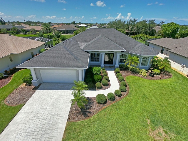 260 Rotonda Blvd E, Rotonda West, FL 33947 - ranch-style house with an attached garage, a front yard, decorative driveway, roof with shingles, and a residential view