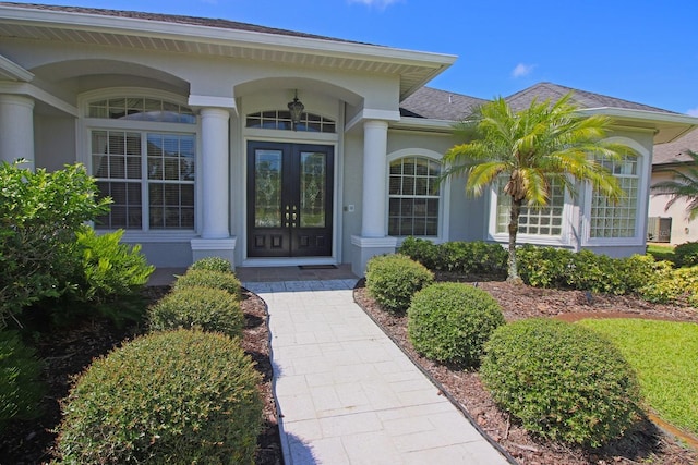 260 Rotonda Blvd E, Rotonda West, FL 33947 - view of exterior entry featuring stucco siding, french doors, and roof with shingles