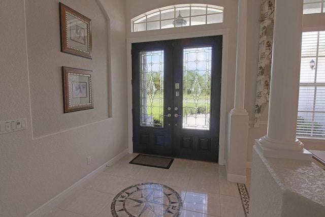 260 Rotonda Blvd E, Rotonda West, FL 33947 - foyer featuring light tile patterned floors, ornate columns, inlaid floor details, and french doors
