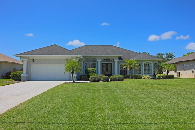 260 Rotonda Blvd E, Rotonda West, FL 33947 - view of front of property featuring a garage, a front yard, decorative driveway, french doors, and stucco siding