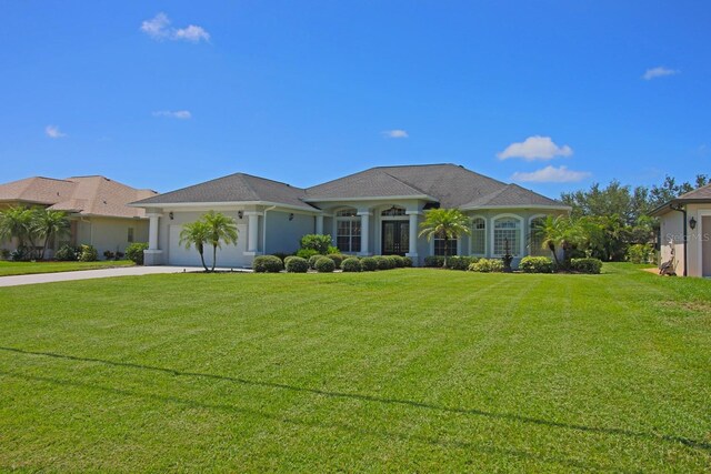 260 Rotonda Blvd E, Rotonda West, FL 33947 - view of front of property featuring driveway, a garage, and a front yard