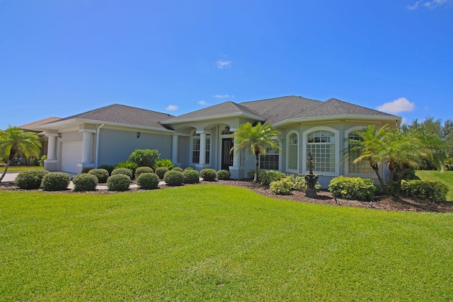 260 Rotonda Blvd E, Rotonda West, FL 33947 - view of front of home featuring a garage, a front yard, and stucco siding