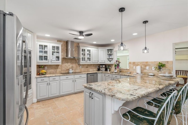123 Annapolis Ln, Rotonda West, FL 33947 - kitchen with wall chimney range hood, appliances with stainless steel finishes, a peninsula, a breakfast bar, and backsplash