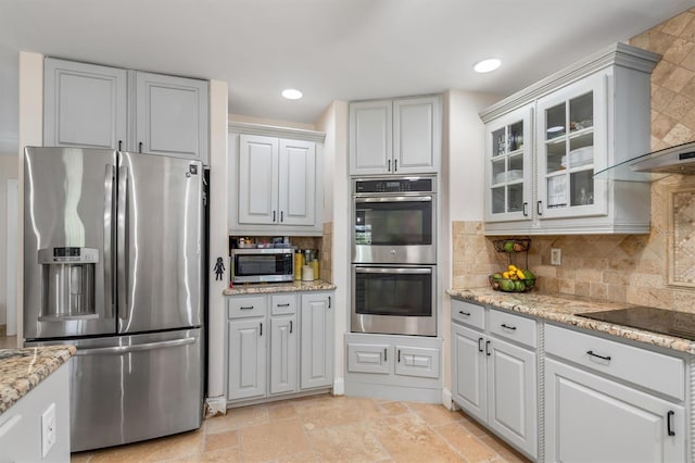123 Annapolis Ln, Rotonda West, FL 33947 - kitchen featuring stainless steel appliances, wall chimney exhaust hood, glass insert cabinets, decorative backsplash, and recessed lighting
