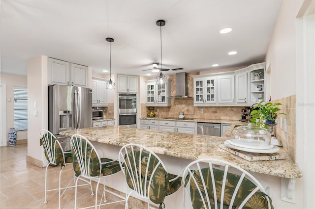 123 Annapolis Ln, Rotonda West, FL 33947 - kitchen with wall chimney range hood, stainless steel appliances, a peninsula, backsplash, and recessed lighting