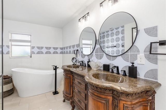 123 Annapolis Ln, Rotonda West, FL 33947 - full bath with double vanity, a freestanding tub, tile patterned flooring, tile walls, and a wainscoted wall