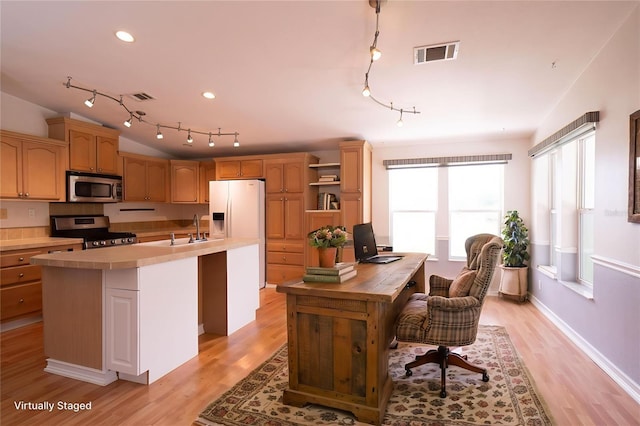 10724 SW Park Ave, Arcadia, FL 34269 - kitchen featuring stainless steel appliances, track lighting, light countertops, a kitchen island with sink, and light wood-type flooring