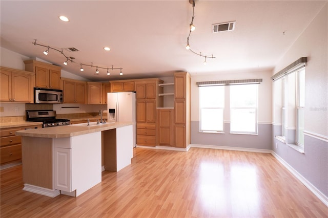 10724 SW Park Ave, Arcadia, FL 34269 - kitchen featuring appliances with stainless steel finishes, rail lighting, light countertops, an island with sink, and light wood-style floors