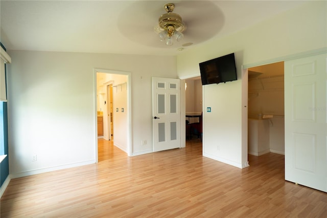 10724 SW Park Ave, Arcadia, FL 34269 - unfurnished bedroom featuring light wood finished floors, a spacious closet, a closet, and a ceiling fan