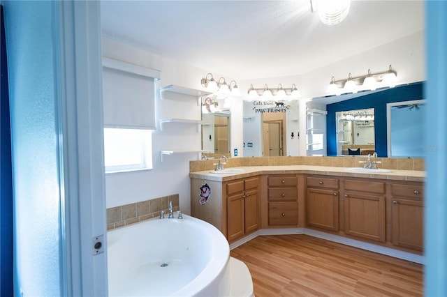 10724 SW Park Ave, Arcadia, FL 34269 - bathroom featuring a bath, double vanity, plenty of natural light, and wood finished floors