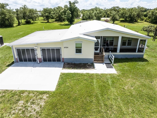 10724 SW Park Ave, Arcadia, FL 34269 - view of front of home featuring a sunroom, driveway, a front lawn, and view of wooded area
