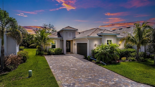14684 Cherry Blossom Way, Punta Gorda, FL 33955 - view of front of property featuring an attached garage, decorative driveway, stucco siding, a lawn, and a tile roof