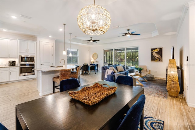 14684 Cherry Blossom Way, Punta Gorda, FL 33955 - dining space featuring a ceiling fan, a tray ceiling, ornamental molding, light wood finished floors, and recessed lighting