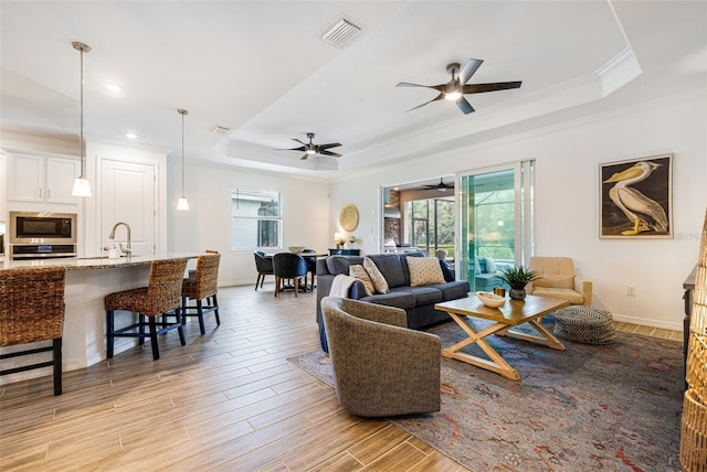 14684 Cherry Blossom Way, Punta Gorda, FL 33955 - living room featuring a raised ceiling, ornamental molding, light wood-style floors, a ceiling fan, and recessed lighting