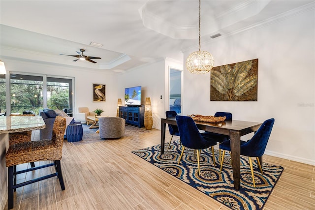 14684 Cherry Blossom Way, Punta Gorda, FL 33955 - dining area with a tray ceiling, ornamental molding, a chandelier, light wood finished floors, and a ceiling fan