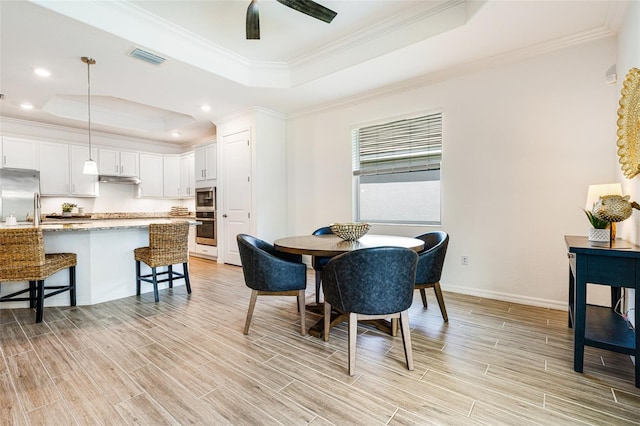 14684 Cherry Blossom Way, Punta Gorda, FL 33955 - dining room with a tray ceiling, crown molding, light wood-type flooring, a ceiling fan, and recessed lighting