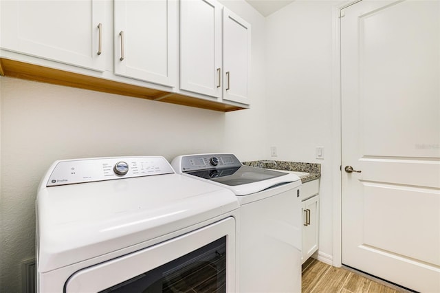 14684 Cherry Blossom Way, Punta Gorda, FL 33955 - laundry room featuring washer and dryer, light wood-style floors, and cabinet space