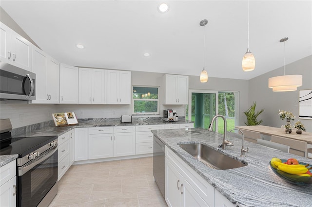 4863 Las Almanos Ave, North Port, FL 34288 - kitchen featuring appliances with stainless steel finishes, white cabinetry, decorative light fixtures, light stone countertops, and recessed lighting