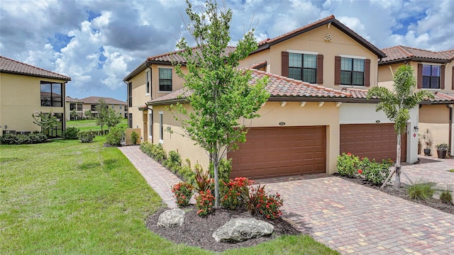 12425 Ghiberti Cir Unit 101, Venice, FL 34293 - view of front facade with a tile roof, stucco siding, a front yard, decorative driveway, and a residential view