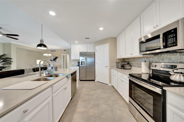 12425 Ghiberti Cir Unit 101, Venice, FL 34293 - kitchen with appliances with stainless steel finishes, a ceiling fan, white cabinets, recessed lighting, and decorative backsplash