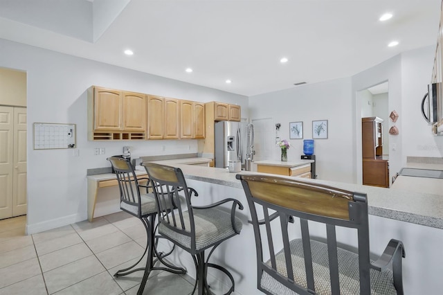 3116 SW 16th Pl, Cape Coral, FL 33914 - kitchen featuring stainless steel appliances, light countertops, light brown cabinets, a kitchen bar, and recessed lighting