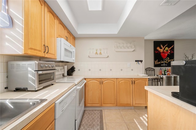 311 Garvin St Unit 301B, Punta Gorda, FL 33950 - kitchen featuring white appliances, backsplash, light tile patterned floors, a raised ceiling, and light countertops