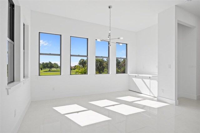 16322 Nogales Ct, Punta Gorda, FL 33955 - empty room featuring plenty of natural light, a chandelier, and tile patterned flooring