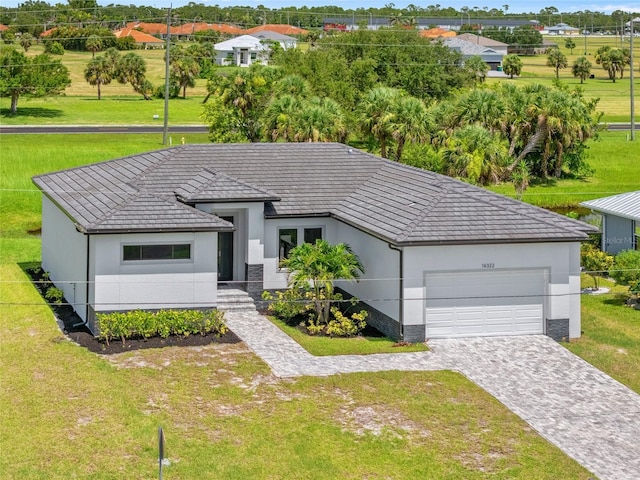 16322 Nogales Ct, Punta Gorda, FL 33955 - view of front of house featuring an attached garage, decorative driveway, a front lawn, and stucco siding