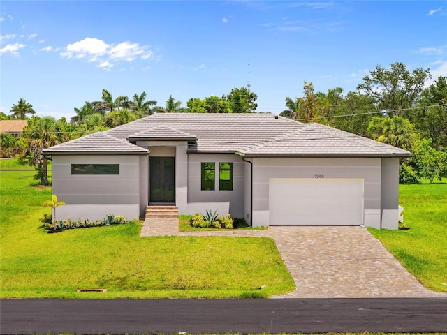 17200 Mint Ln, Punta Gorda, FL 33955 - prairie-style house featuring a front yard, a garage, stucco siding, decorative driveway, and french doors