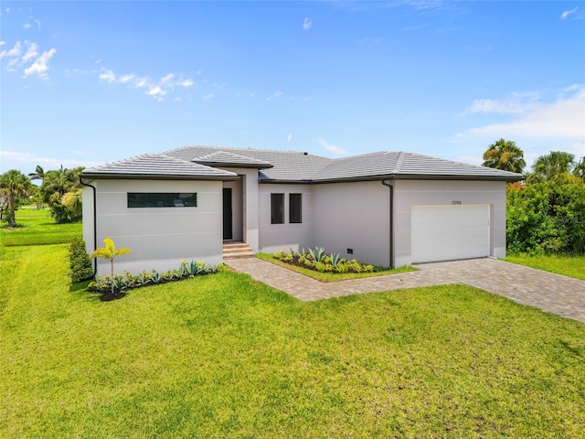 17200 Mint Ln, Punta Gorda, FL 33955 - prairie-style home featuring an attached garage, a tile roof, a front lawn, driveway, and stucco siding