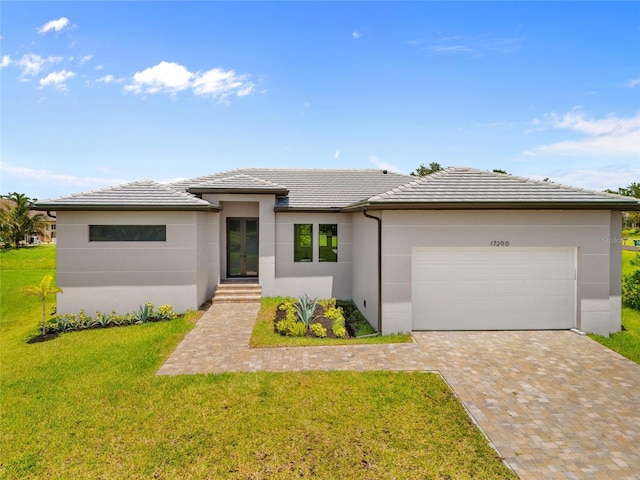 17200 Mint Ln, Punta Gorda, FL 33955 - prairie-style home featuring stucco siding, a garage, a front yard, a tiled roof, and decorative driveway