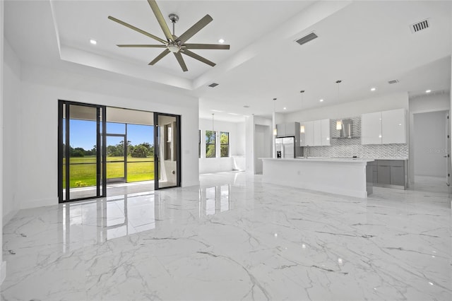 16506 Cape Horn Blvd, Punta Gorda, FL 33955 - unfurnished living room featuring a tray ceiling, a ceiling fan, light marble finish floors, and recessed lighting