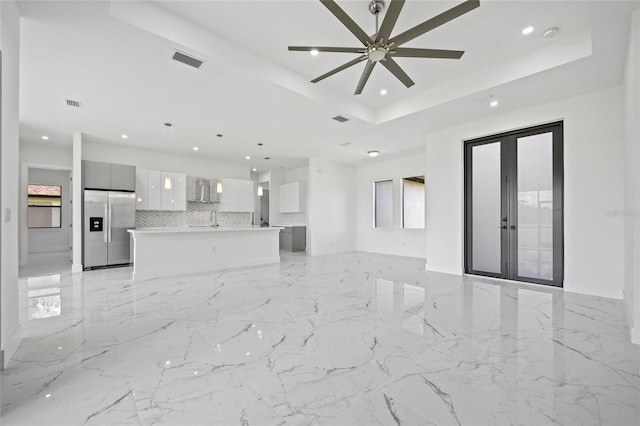 16506 Cape Horn Blvd, Punta Gorda, FL 33955 - unfurnished living room featuring a raised ceiling, recessed lighting, healthy amount of natural light, and light marble finish floors